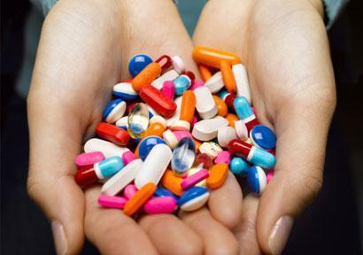 woman-holding-pills_410x290